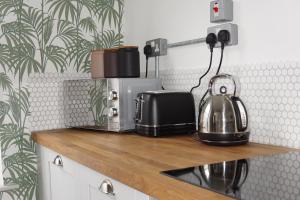 eine Küchentheke mit einem Toaster und einer Kaffeemaschine in der Unterkunft High St. Hideout in Caernarfon