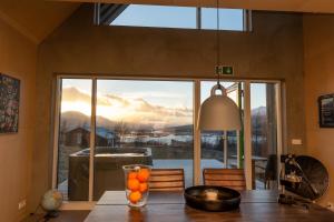 einen Esstisch mit einem großen Glasfenster in der Unterkunft Viking Cottages & Apartments in Akureyri