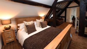 a bedroom with a large bed with white sheets and pillows at Ye Olde Punchbowl Country Inn & Gardens in Bridgnorth