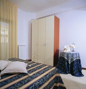 a bedroom with a large bed with a cabinet at Residence Vittoria in Alba Adriatica