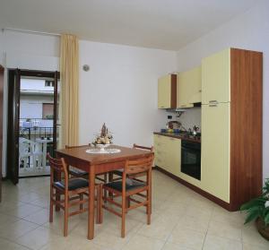 uma cozinha com uma mesa e cadeiras e um frigorífico em Residence Vittoria em Alba Adriatica