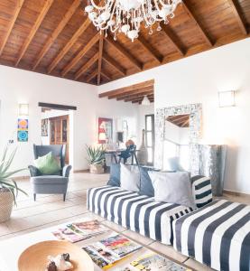 a living room with a couch and a chandelier at Kalufa Surf House in El Cuchillo