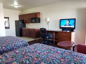 a hotel room with two beds and a flat screen tv at Crossroads Inn & Suites in Victoria
