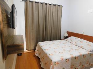 Dormitorio pequeño con cama y TV en Hotel Real São Lourenço, en São Lourenço