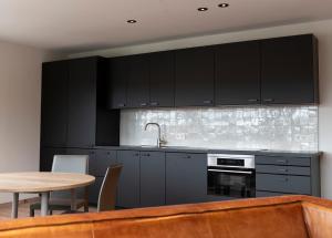 a kitchen with black cabinets and a table at Mooiwater in Deinze