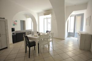 a white dining room with a white table and chairs at Corso Garibaldi 22 apartment in Paola