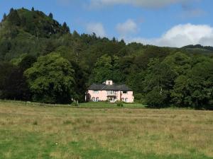 a house in a field in front of a mountain at Melfort House in Kilmelfort