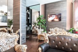 un vestíbulo con un sofá con estampado de leopardo y sillas en Canova Hotel, en Milán