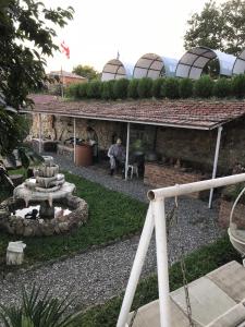 a man sitting in a garden with a fire place at Hotel Eurica in Kutaisi