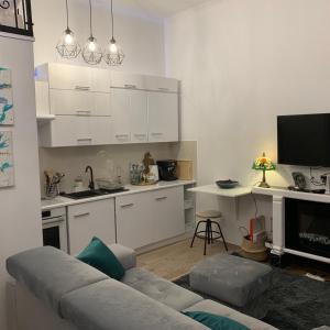 uma sala de estar com um sofá e uma cozinha em Charming studio apartment in the heart of the Jewish District! em Cracóvia