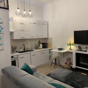 a living room with a couch and a kitchen at Charming studio apartment in the heart of the Jewish District! in Kraków