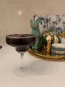 uma mesa com um copo de vinho e uma estatueta de gato em Charming studio apartment in the heart of the Jewish District! em Cracóvia