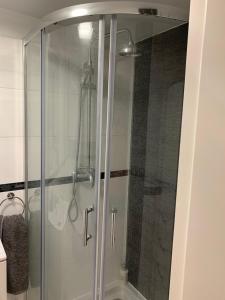 a shower with a glass door in a bathroom at Charming studio apartment in the heart of the Jewish District! in Kraków