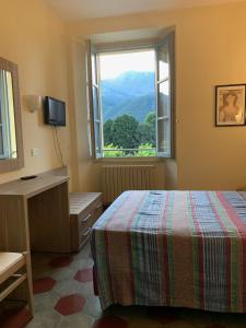 a bedroom with a bed and a window with a view at Albergo Maggio in Cremeno