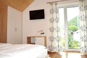 - une chambre avec un lit et une grande fenêtre dans l'établissement Przystań Park Dolny, à Szczawnica