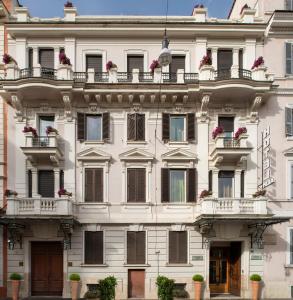 um grande edifício branco com janelas e varandas em Alpi Hotel em Roma