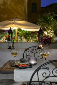 a table with two glasses of wine and a plate of food at Alpi Hotel in Rome