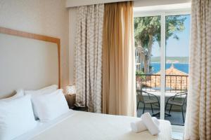 a bedroom with a bed and a balcony with a view at Karalis Beach in Pylos