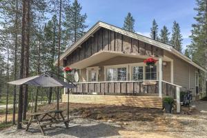 una pequeña casa con una mesa de picnic y una sombrilla en Villa Haukka en Saariselka