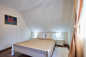 um pequeno quarto com uma cama branca e uma janela em Green lakes house em Plitvicka Jezera