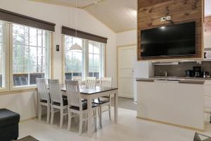 a dining room with a table and chairs and a television at Villa Haukka in Saariselka