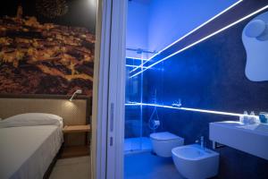 La salle de bains bleue est pourvue de toilettes et d'un lavabo. dans l'établissement La Lupa, à Matera