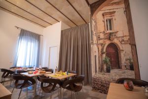 une salle à manger avec des tables, des chaises et un rideau dans l'établissement La Lupa, à Matera