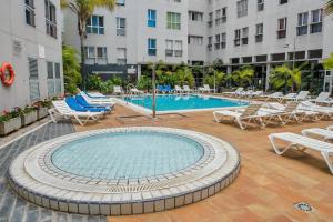 a swimming pool with lounge chairs and a hotel at Sardina Penthouse Dreams in Gáldar