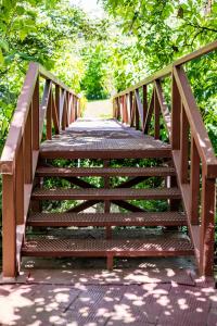 a wooden bridge over a walkway in a park at La Terraza Guest House B&B in Grecia