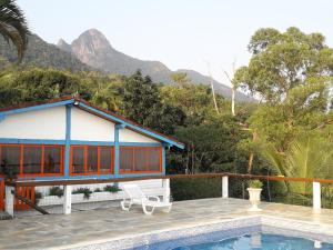 a house with a swimming pool in front of a house at Casa das Ilhas in Ilhabela
