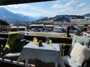 een tafel en stoelen op een balkon met uitzicht op de stad bij Gästehaus Burger in Fischen