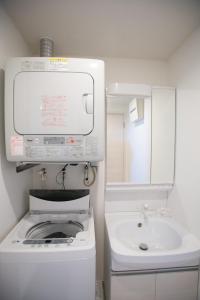 a white bathroom with a toilet and a sink at Airy House I / Vacation STAY 46400 in Onna