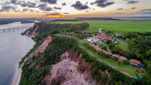 uma vista aérea de uma casa num penhasco perto da água em Gungaporanga Hotel na Barra de São Miguel