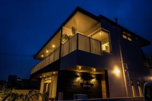 a black building with a balcony at night at Ginowan - House / Vacation STAY 46771 in Ginowan