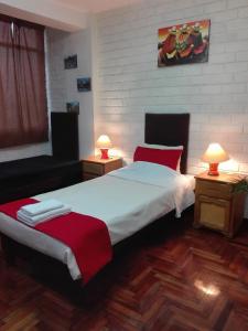 a bedroom with two beds and two lamps on tables at Miraflores Centre in Lima