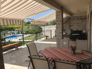 a patio with a table and chairs and a pool at Vila Nikola in Bratesici