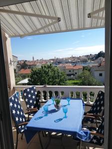een tafel op een balkon met uitzicht op de stad bij Apartmani Paula in Rab