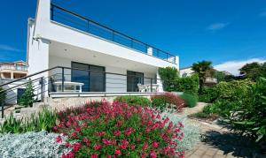 een wit huis met een balkon en bloemen bij MIDAVkl in Pirovac