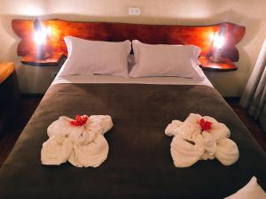 two towels on a bed in a hotel room at Pousada Recanto das Marias in Santo Antônio do Pinhal