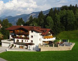 a large white building with a brown roof at Pension Edelweiss in Breitenbach am Inn