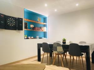 ein Esszimmer mit einem Tisch, Stühlen und einer Dartscheibe in der Unterkunft Game Place (entre lac et montagne) in Thonon-les-Bains