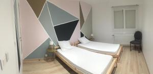 2 Betten in einem Zimmer mit einer geometrischen Wand in der Unterkunft Game Place (entre lac et montagne) in Thonon-les-Bains + 24 Fotos