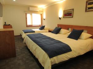 Ein Bett oder Betten in einem Zimmer der Unterkunft Hotel Pucón Indómito