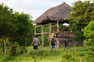 Un gruppo di persone che si trovano davanti a una capanna di Mida Creek Nature Camp a Watamu