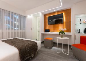 a hotel room with a bed and a vase of flowers at 45 by Director in Santiago