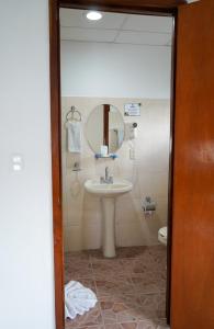 y baño con lavabo, espejo y aseo. en Hotel & Suites Arges - Centro Chetumal en Chetumal