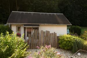 une petite maison derrière une clôture en bois dans l'établissement Kleines Ferienhaus zu Füßen des Rennsteigs, à Ruhla