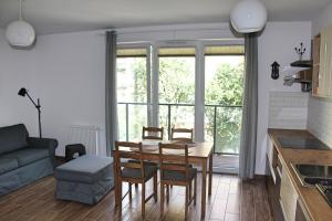 a kitchen and living room with a table and chairs at Apartament Spacerowa in Wejherowo