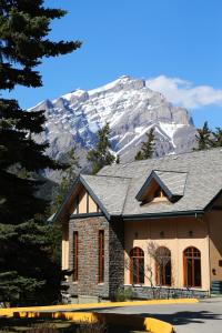 una casa con una montaña cubierta de nieve en el fondo en YWCA Banff Hotel, en Banff