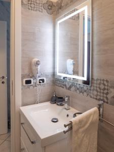 a bathroom with a white sink and a mirror at Albachiara Suite Rooms in Bologna +38 photos